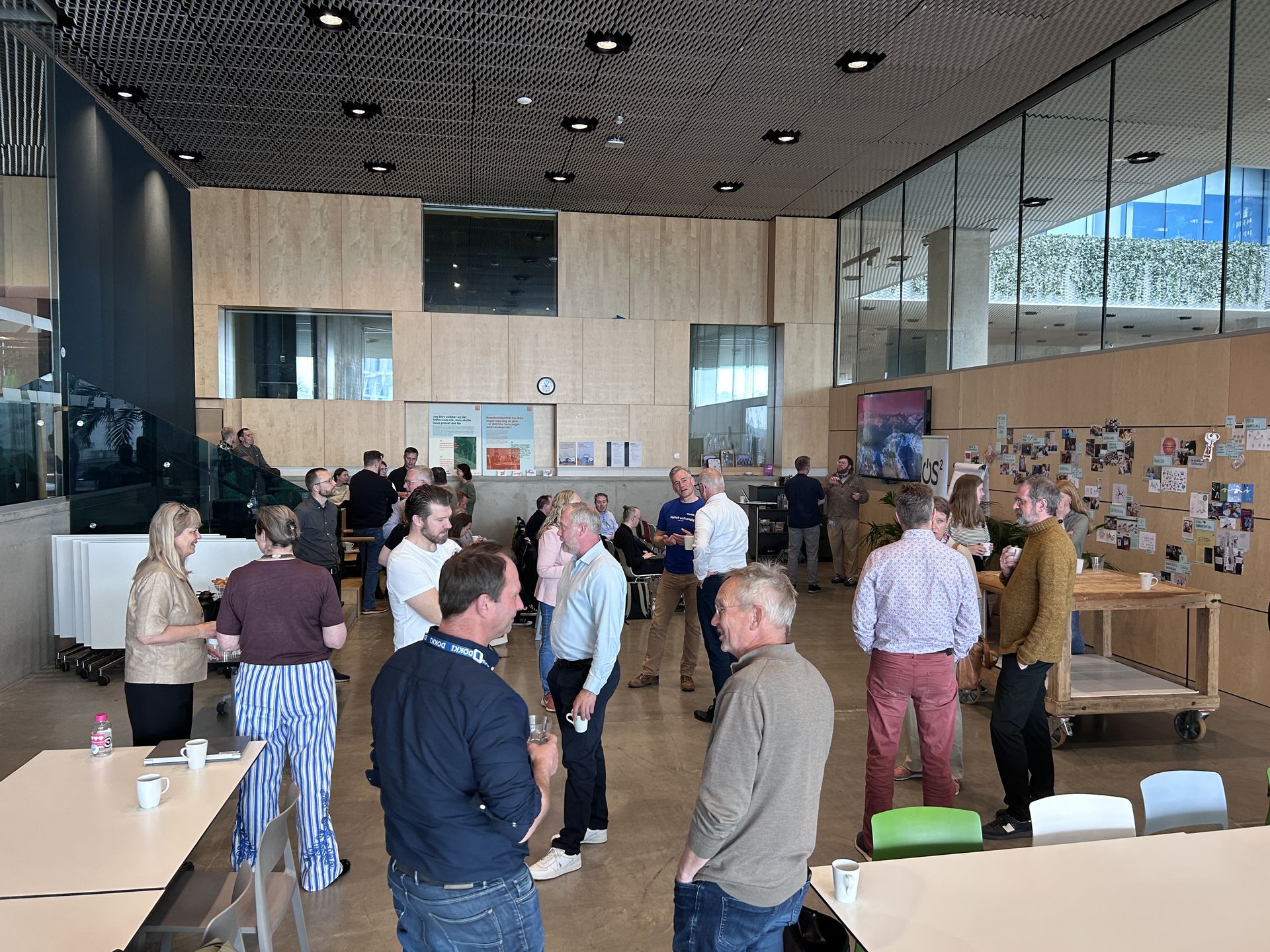 OS2-deltagere netværker i pausen ved generalforsamling i et lyst lokale hos ITK på Dokk1 i Aarhus.